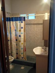 a bathroom with a shower curtain and a sink at Los Nonos in Perdriel