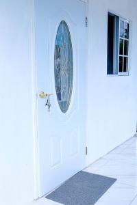 a white door with a round window on it at Sharays Hideaway in Bull Bay