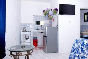 a white kitchen with a table and a refrigerator at Sharays Hideaway in Bull Bay