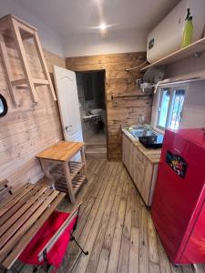 a kitchen with a red refrigerator and a wooden floor at El estudio de César in Conil de la Frontera