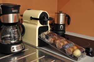 a kitchen counter with a coffee maker and a rack of cups at Champs Elysees Executive Apartment in Paris