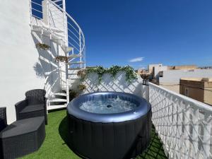 a hot tub on the balcony of a building at Pergola Penthouse Xaghra in Xagħra