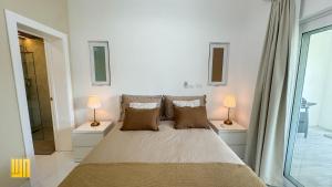 a bedroom with a large bed with two lamps at 2JA Management Group - Condos White Hill in Sosúa +75 photos