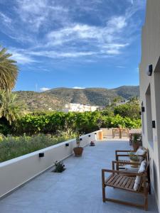 a patio with benches and a view of the mountains at Kapetánissa Concept Studios in Stalís