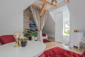 a living room with a white table and a red rug at The Nest Apartment in Sovata