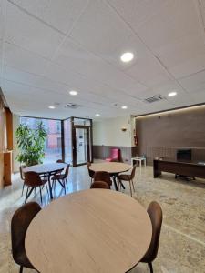 a room with tables and chairs and a piano at Hostal Lizana 2 in Huesca