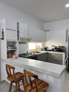 a kitchen with two chairs and a white counter top at Casa Privada con Piscina in Salinas