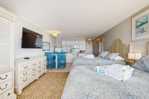 a large bedroom with two beds and a kitchen at Oceanfront suite with bay views full kitchen balcony AC & firepit in North Truro