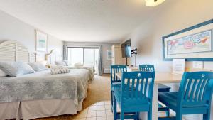 a bedroom with a bed and a desk and chairs at Oceanfront suite with bay views full kitchen balcony AC & firepit in North Truro