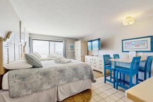 a bedroom with a bed and a table and chairs at Oceanfront suite with bay views full kitchen balcony AC & firepit in North Truro