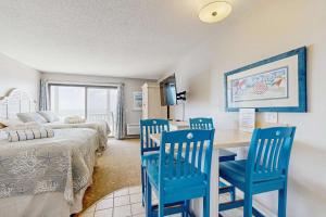a bedroom with two beds and a desk with blue chairs at Oceanfront suite with bay views full kitchen balcony AC & firepit in North Truro +21 photos