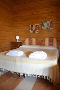 a bed in a wooden room with towels on it at Il Giardino Del Sole in Agnone Bagni