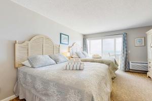 a bedroom with two beds and a large window at Oceanfront getaway with Bay-view balcony full kitchen AC in North Truro