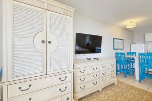 a bedroom with a large dresser and a tv at Oceanfront getaway with Bay-view balcony full kitchen AC in North Truro