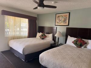 a hotel room with two beds and a ceiling fan at Morro Crest Inn in Morro Bay