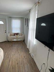 a living room with a couch and a flat screen tv at Philly Content House in Marcus Hook