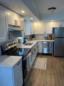 a kitchen with white cabinets and stainless steel appliances at Philly Content House in Marcus Hook