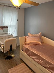 a bedroom with a bed and a desk and a window at Philly Content House in Marcus Hook