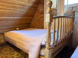 a bed in a room with a wooden wall at Skruzdėlynas in Nida +7 photos