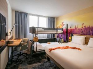 a hotel room with a bed and a desk and a bunk bed at Novotel Antibes Sophia Antipolis in Valbonne +141 photos