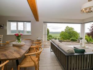 a living room with a couch and a table and chairs at Barn Howe in Kendal