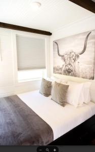 a bedroom with a large bed with a painting of a bull at NEW! Cozy Container Home at Cliffside #4 in Orderville