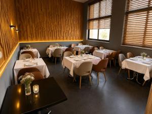 a dining room with tables and chairs with white tablecloths at Hotel Vents Des Iles in Essaouira