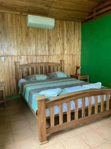 a bedroom with a wooden bed and a green wall at Hostal Flor de Pochote in Masatepe +42 photos
