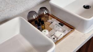 a sink with bottles in a drawer under a sink at Thy Executive Hotel in Johor Bahru