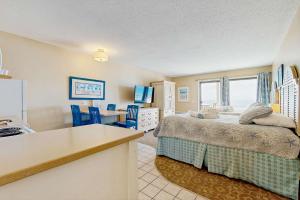 a bedroom with a bed and a kitchen with a table at Oceanfront hideaway with full kitchen AC sunrise-view balcony in North Truro