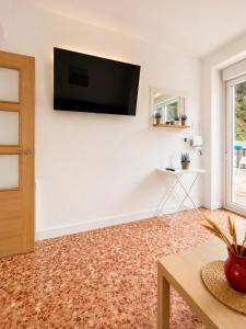 a living room with a flat screen tv on a white wall at Fantastico retiro rural en el corazon de Euskadi in Elgóibar