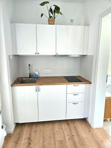 a kitchen with white cabinets and a sink at Sonnenschein Apartment in Falkensee