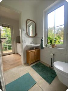 a bathroom with a toilet and a sink and a mirror at Sonnenschein Apartment in Falkensee