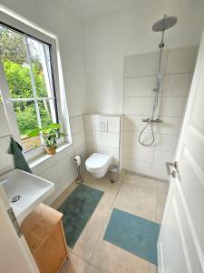 a bathroom with a toilet and a sink and a shower at Sonnenschein Apartment in Falkensee