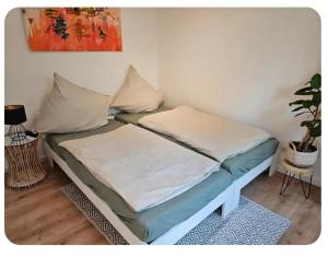 a bed with two pillows on it in a room at Sonnenschein Apartment in Falkensee