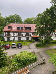 a large building with cars parked in a parking lot at Neue Mühle Kleines Landhotel in Brandenburg an der Havel