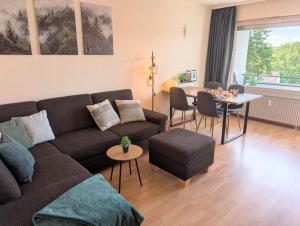 a living room with a couch and a table at MeLou FeWo NaturQuartier Wellness in Bad Lauterberg