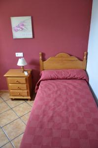 1 dormitorio con 1 cama y 1 mesa con lámpara en Casa Rural Pastora Marcela, en Saceruela