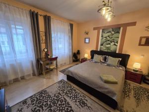 a bedroom with a bed and a desk and window at Atia Residence in Sibiu