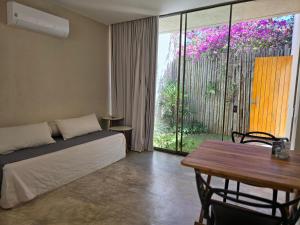 a bedroom with a bed and a table and a window at Statera Host - Pousada de Bem-Estar in Alto Paraíso de Goiás +128 photos