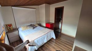 a small bedroom with a bed and a red cabinet at Refúgio in Ouro Preto