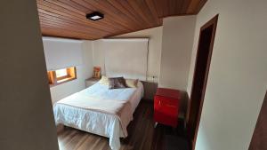a small bedroom with a bed and a window at Refúgio in Ouro Preto