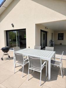 a white table and chairs on a patio at Modern Vosges Getaway in Laveline