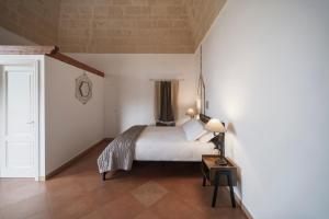a bedroom with a bed and a table with a lamp at Dimora Santa Barbara in Matera
