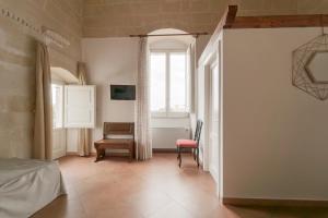 a bedroom with a bed and a chair and a window at Dimora Santa Barbara in Matera