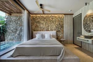 a bedroom with a large bed and a window at Karidi Beach Gaia Retreat in Vourvourou