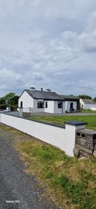 a white house on the side of a road at Bridie's Cottage in Mullagh