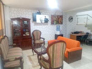 a living room with an orange couch and chairs at HOTEL DEL PARQUE VELEZ Santander in Vélez
