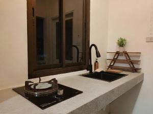 a kitchen counter with a sink and a mirror at Nirvana By the Sea in Ban Madua Wan