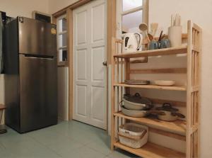a kitchen with a refrigerator and wooden shelves at Nirvana By the Sea in Ban Madua Wan +8 photos